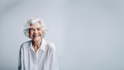 Wall Mural - Beautiful old woman smiling isolated on studio background. Copyspace area