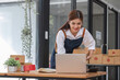 © chartchai - Startup small business entrepreneur SME, asian woman packing cloth in box. Portrait young Asian small business owner home office, online sell marketing delivery, SME e-commerce telemarketing concept