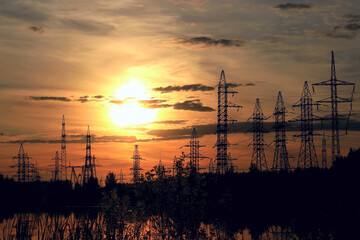 Wall Mural - Silhouette high voltage electric tower on summer sunset background.