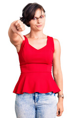 Sticker - Beautiful young woman with short hair wearing casual style with sleeveless shirt looking unhappy and angry showing rejection and negative with thumbs down gesture. bad expression.