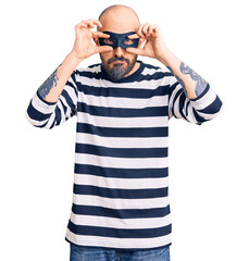 Poster - Young handsome man wearing burglar mask trying to open eyes with fingers, sleepy and tired for morning fatigue