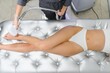 © Serhii - The cosmetologist does laser hair removal of the legs