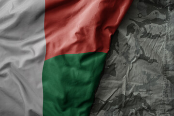 Wall Mural - waving flag of madagascar on the old khaki texture background. military concept.