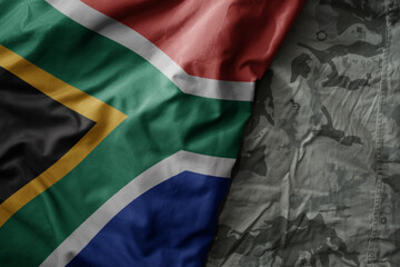 Wall Mural - waving flag of south africa on the old khaki texture background. military concept.