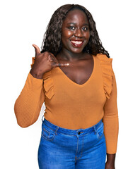 Canvas Print - Young african woman wearing casual clothes smiling doing phone gesture with hand and fingers like talking on the telephone. communicating concepts.