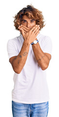 Wall Mural - Young hispanic man wearing casual white tshirt shocked covering mouth with hands for mistake. secret concept.