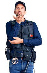 Poster - Young handsome man wearing police uniform looking at the camera blowing a kiss with hand on air being lovely and sexy. love expression.