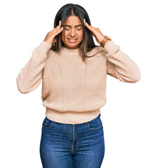 Poster - Young latin girl wearing wool winter sweater with hand on head, headache because stress. suffering migraine.