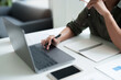 © mojo_cp - Businesswoman using laptop with technology to typing and working about calculation tax in office