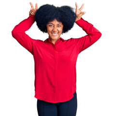 Sticker - Young african american girl wearing casual clothes posing funny and crazy with fingers on head as bunny ears, smiling cheerful