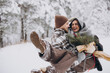 © anatoliycherkas - Cute young couple in love with pine bouquet spending time on Valentine's day in snowy winter forest in mountains