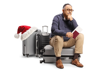 Sticker - Pensive mature man sitting on a suitcase and waiting with a passport