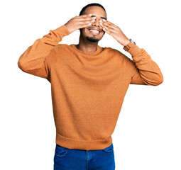 Wall Mural - Young african american man wearing casual clothes covering eyes with hands smiling cheerful and funny. blind concept.