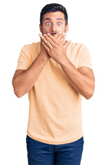 Canvas Print - Young hispanic man wearing casual clothes shocked covering mouth with hands for mistake. secret concept.