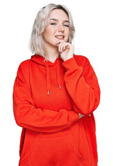 Canvas Print - Young blonde girl wearing casual clothes looking confident at the camera with smile with crossed arms and hand raised on chin. thinking positive.