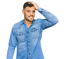 Sticker - Young hispanic man wearing casual denim jacket confuse and wonder about question. uncertain with doubt, thinking with hand on head. pensive concept.