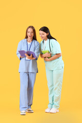 Sticker - Female medical students with copybooks on yellow background