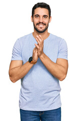 Wall Mural - Young hispanic man wearing casual clothes clapping and applauding happy and joyful, smiling proud hands together