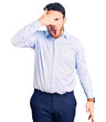 © Krakenimages.com - Young hispanic man wearing business clothes peeking in shock covering face and eyes with hand, looking through fingers with embarrassed expression.