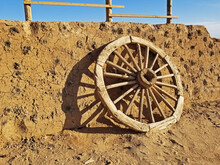 Old Wagon Wheel Leaning Against A Mud Wall In A Desert Village In Inner Mongolia, China, On A Sunny Day -25