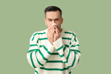 Poster - Sick young man with tissue on green background