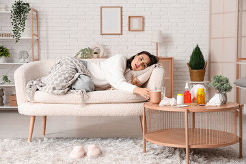 Sticker - Sick young woman on sofa taking glass of water from table at home