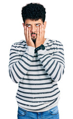 Wall Mural - Young arab man with beard wearing casual striped sweater tired hands covering face, depression and sadness, upset and irritated for problem