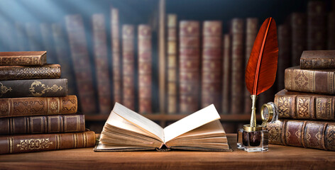 Old books ,quill pen and vintage inkwell in old library. Conceptual background on history, education, ancient, literature topics. Old Books are symbol of knowledge. Retro style.