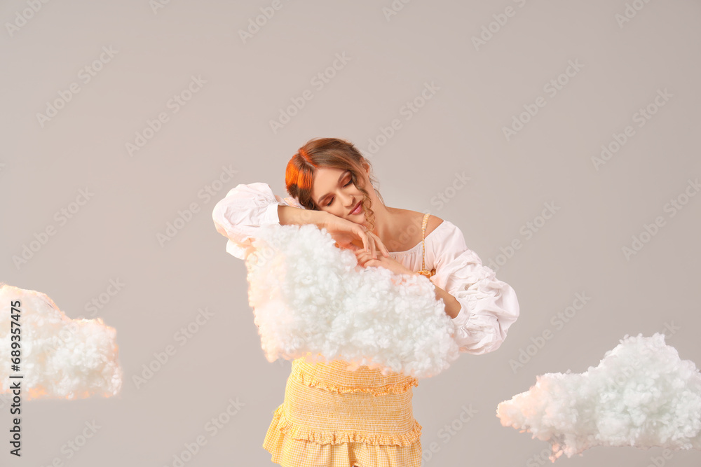 Beautiful woman with white clouds on light background