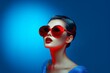© Nata - Close up portrait, beautiful Japanese middle aged woman with red sunglasses. Bold, vivid colors. Blue background with back light and copy space. Minimal concept of fashion, beauty, style and elegance.