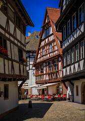 Poster - Ornate traditional half timbered houses with blooming flowers along the canals in the picturesque Petite France district of Strasbourg, Alsace, France