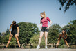 © qunica.com - Active women training outdoors in a city park, enjoying a sunny day. They engage in pre-workout exercises, stretching, and warming up together, reflecting their commitment to a healthy lifestyle.