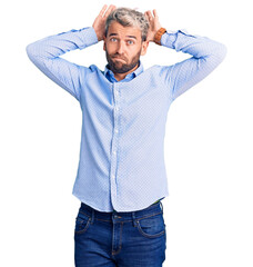 Wall Mural - Young handsome blond man wearing elegant shirt doing bunny ears gesture with hands palms looking cynical and skeptical. easter rabbit concept.