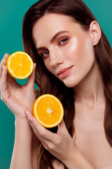 Vertical photo of cute smiling lady naked shoulders holding two citrus halves isolated green color background