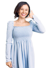 Wall Mural - Young beautiful girl wearing casual clothes smiling doing phone gesture with hand and fingers like talking on the telephone. communicating concepts.