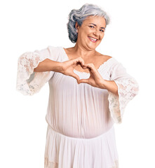 Sticker - Senior woman with gray hair wearing bohemian style smiling in love doing heart symbol shape with hands. romantic concept.