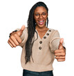 © Krakenimages.com - African american woman wearing casual clothes approving doing positive gesture with hand, thumbs up smiling and happy for success. winner gesture.