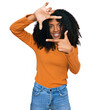 © Krakenimages.com - Young african american girl wearing casual clothes smiling making frame with hands and fingers with happy face. creativity and photography concept.