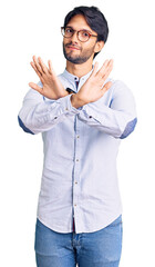 Poster - Handsome hispanic man wearing business shirt and glasses rejection expression crossing arms and palms doing negative sign, angry face