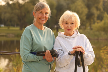 Two senior women with Nordic walking poles outdoors