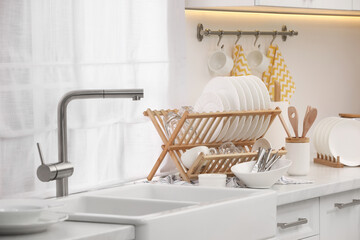 Poster - Sink and drying rack with clean dishes and cutlery on countertop in kitchen