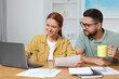 © New Africa - Couple doing taxes at table in room