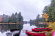 © Michael Connor Photo - canoes on the shore of a calm reflective part of the lower madawaska river ontario in fall with autumn color room for text