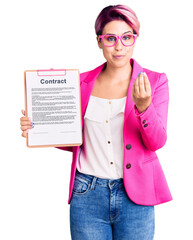 Poster - Young beautiful woman with pink hair holding clipboard with contract document doing money gesture with hands, asking for salary payment, millionaire business