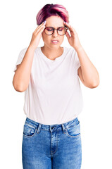 Canvas Print - Young beautiful woman with pink hair wearing casual clothes and glasses with hand on head for pain in head because stress. suffering migraine.