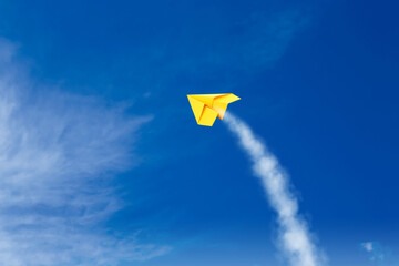 Sticker - Yellow paper plane flying in blue sky with clouds