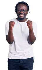 Sticker - Young african american man with braids wearing casual white tshirt excited for success with arms raised and eyes closed celebrating victory smiling. winner concept.