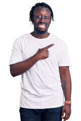 Poster - Young african american man with braids wearing casual white tshirt pointing aside worried and nervous with forefinger, concerned and surprised expression