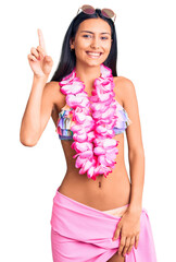 Poster - Young beautiful latin girl wearing bikini and hawaiian lei pointing finger up with successful idea. exited and happy. number one.