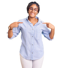 Poster - Young african american woman with braids wearing casual clothes and glasses looking confident with smile on face, pointing oneself with fingers proud and happy.